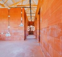 The interior of a family house with unfinished brick walls and exposed wiring.