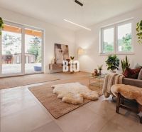 Living room in a family house with plants, large windows, and pleasant lighting.