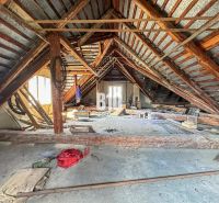 The attic of a family house in Púchov with wooden beams and clutter.