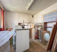 Room in a family house with stored furniture and an old washing machine.