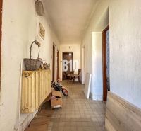 A narrow hallway in a family house with retro decorations and an older radiator.
