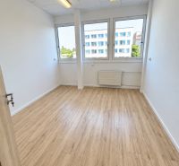 An office with a wooden floor design, interior with large windows and ceiling lighting.