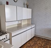 A kitchen in a family house with a gas stove and a wooden decor floor.