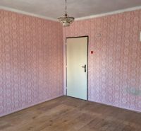 An interior in a family house with wallpaper and flooring with a wood design.