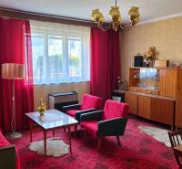 Living room in a family house with red curtains and vintage furniture.