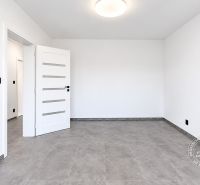An empty room in a 2-room apartment with ceramic flooring and white walls.