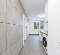 A kitchen in a 2-room apartment with tiles and a view through a large window.