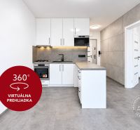 A kitchen in a 2-room apartment with white cabinets and a gray floor.
