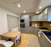 A kitchen in a family house with a modern kitchen unit and a floor with a wooden decor.