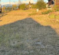 A garden at a family house in Blatné Revištia with grass cover and the sky in the background.