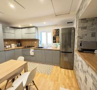 A kitchen in a family house with a wooden decor floor, equipped with modern appliances.