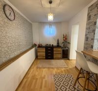 Interior of a family house with a wall featuring a stone design and a floor with a wood design.