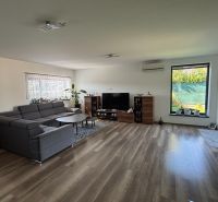 Living room in a family house with a dark sofa set and a floor with a wooden decor.