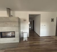 A fireplace in a family house with a wooden decor floor and light-colored walls.