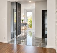 The 3-room apartment has a floor with a wooden decor and a bright kitchen in the background.