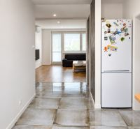 Interior of a 3-room apartment with a wooden decor floor and ceramics, living room in the background.