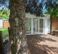 A terrace by the house on Recreational Land in Bratislava - Devín surrounded by greenery and trees.