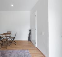 A simple interior with a wooden table and chairs on a floor with a wooden decor.