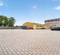 Parking lot and yellow building on Brnianska Street in Trenčín, suitable for offices.