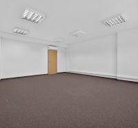 Spacious office spaces with carpet and white walls.