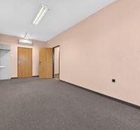 There is a sink, two doors, and light walls in the office.