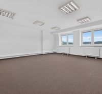 Spacious offices with white walls, carpeted floors, and large windows with a view.