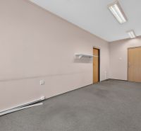 Offices with pinkish walls, gray carpet, wooden doors, wall shelf, and lighting.