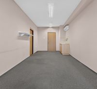 Offices with carpet and a small kitchenette, a simple space for work or meetings.
