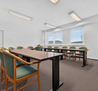 Meeting room with a long table and chairs, simple lighting, offices.
