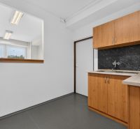 Offices with gray flooring, wooden cabinet decor, and a window for natural light.