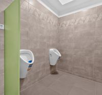 Interior of an office with wall paneling and two urinals.