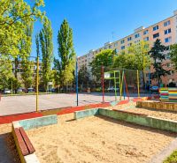 A playground surrounded by greenery and panel buildings on Rumančekova Street, Bratislava - Ružinov.