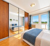 Bright bedroom with a large built-in wardrobe and a view in a 3-room apartment.