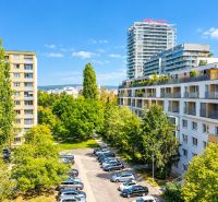 View from a 3-room apartment on Rumančekova Street in Bratislava - Ružinov, with a park and parking lot.