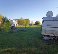 A caravan in the gardens at Tatranská 201 in Zlaté Moravce surrounded by trees and grass.