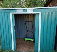 Gardens at Tatranská 201 in Zlaté Moravce with a metal shed and a lawnmower inside.
