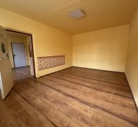A room with a wooden floor decor in a studio apartment with yellow walls.