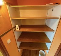 A shelf with four wooden shelves in a studio apartment, floor with wooden decor.