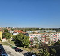 View of Bystrická Street in Pezinok with studio apartments and greenery.