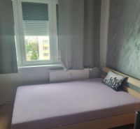 Bedroom in a 3-room apartment with a bed and a gray decorative pillow.