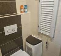 Bathroom with toilet in a 3-room apartment, cream-brown tiles and storage space.