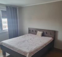 A bedroom in a 3-room apartment with a bed and a wooden decor floor.