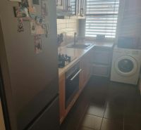 A kitchen in a 3-room apartment with a refrigerator, stove, and washing machine.