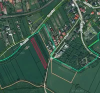 Aerial view of agricultural and forest lands in Podhájska with visible road network.