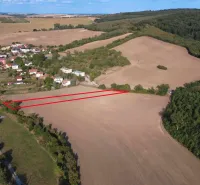 Aerial view of agricultural and forest lands near Podhájska surrounded by the village and forest.