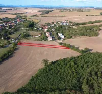Aerial view of agricultural and forest lands in Podhájska surrounded by the village and nature.