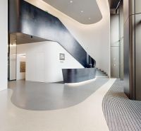 Modern office spaces with minimalist design and a curved staircase.