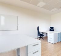 White offices with wood-patterned flooring, desks, and office chairs.