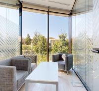 Offices with glass walls, chairs, and a wooden decor floor.