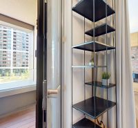Interior of a 2-room apartment with shelves, curtains, and a view of the balcony.